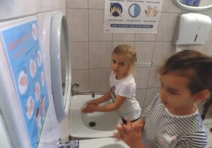 Nadia i Lena ćwiczą prawidłowe mycie rąk przy umywalce.